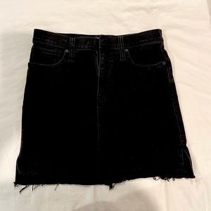 Madewell black denim skirt. Frayed hem that is shorter in front than in back.